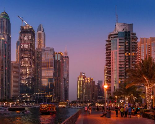 A stunning view of the Dubai Marina skyline illuminated at sunset, showcasing urban city life.